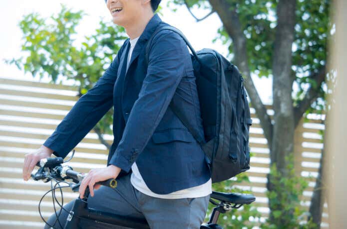 アウトドアブランドのリュックを背負って通勤する人