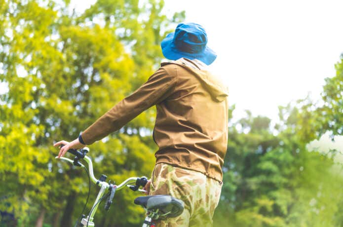 薄手ジャケットを着用してサイクリングをする人