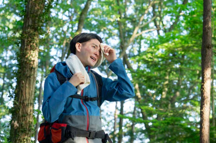汗を拭く登山者