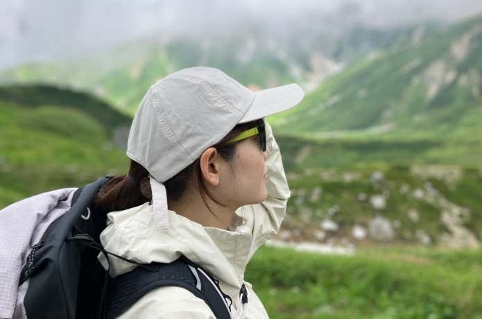風を通す ちいさくまとまる キャップを山でかぶる女性