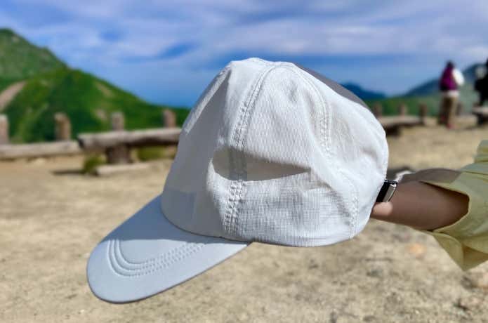 風を通す ちいさくまとまる キャップを山で手に持つ様子
