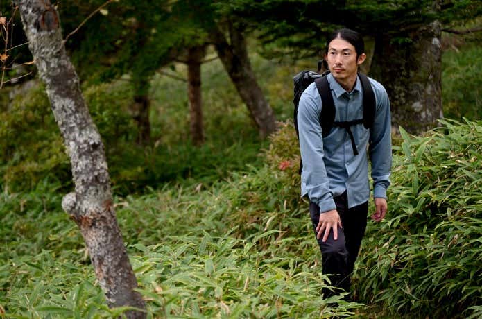 ファイントラックのラミースピンニットシャツを着て山を登る人