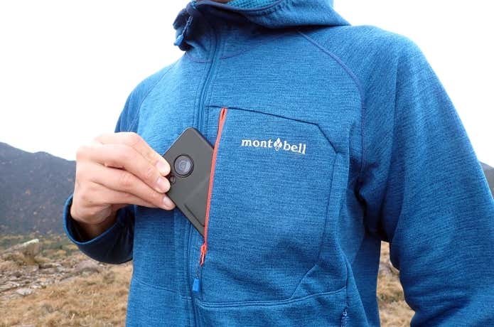 モンベルのクリマグリッドパーカの胸ポケットをレビューする登山者