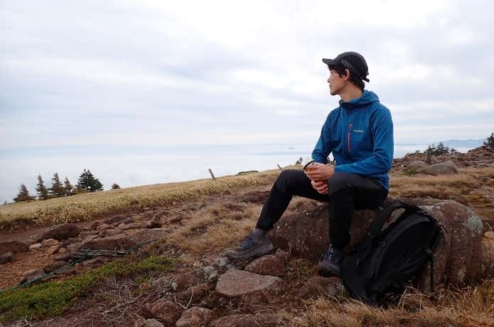 モンベルのクリマグリッドパーカの保温力を休憩シーンでレビューする登山者