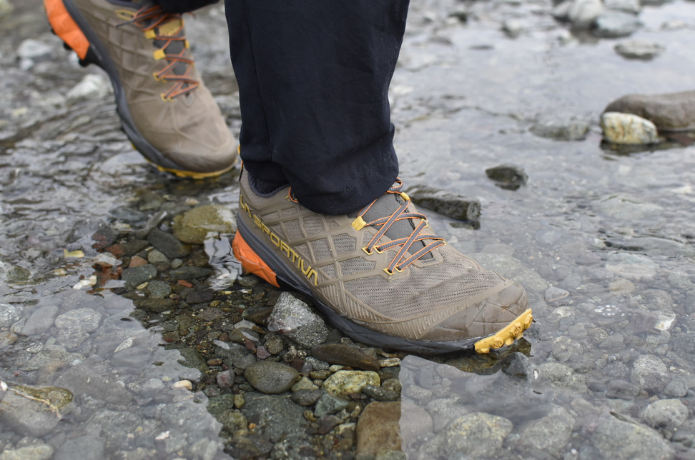 登山靴を履いて水辺を歩く人