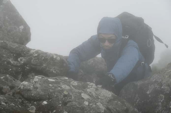 ミューラップフーディを着て岩場を登る人