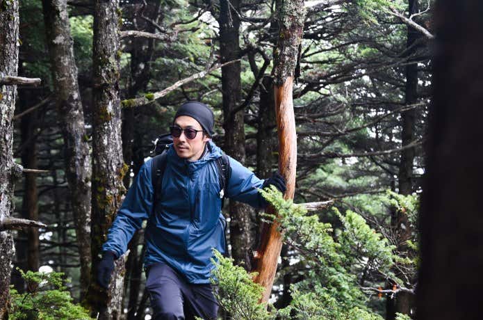 ミューラップフーディを着て山を歩く人