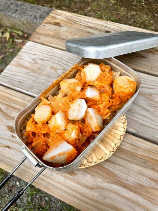 ③ 里芋と豚肉を入れて蓋をし、固形燃料で約25分炊く。

④ 火が消えたら、タオルなどで包み10分ほど蒸らす。混ぜてから最後に白ごまをかけて出来上がり。