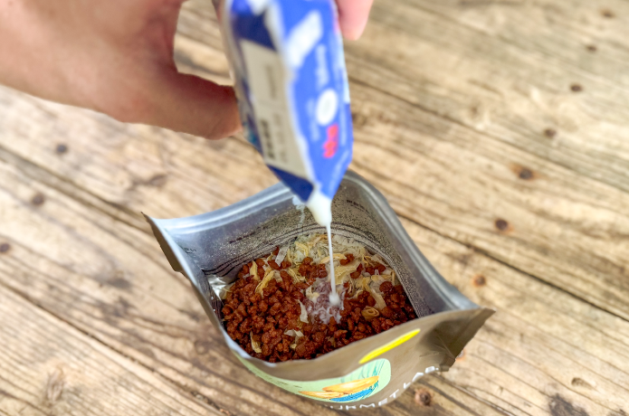 マウンテングルメラボのすじ青のり香るポテトピュレにとりそぼろ、牛乳を入れる