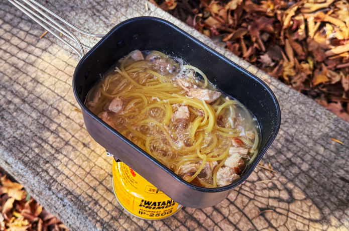 クッカーにパスタとサラダチキンを入れる