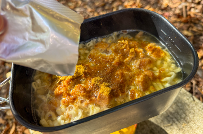 うどんにカレーうどんのスープを加える様子