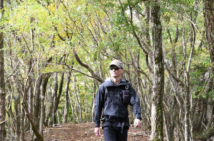 山の中をカリマーのウォームキャップをかぶって歩く男性