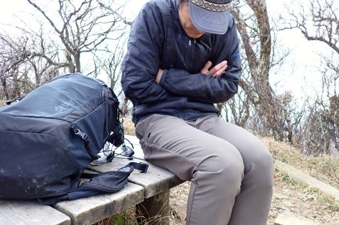 冬山の休憩で寒がる登山者
