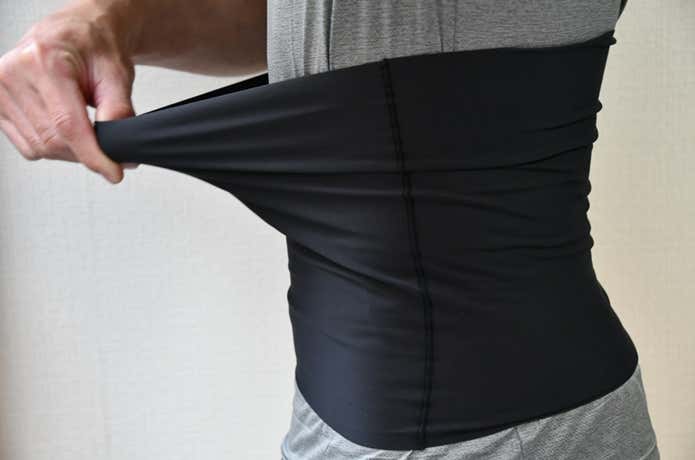 微起毛あったかハラマキを着用し、生地を引っ張ってかなりストレッチがきくことを確認しているところ