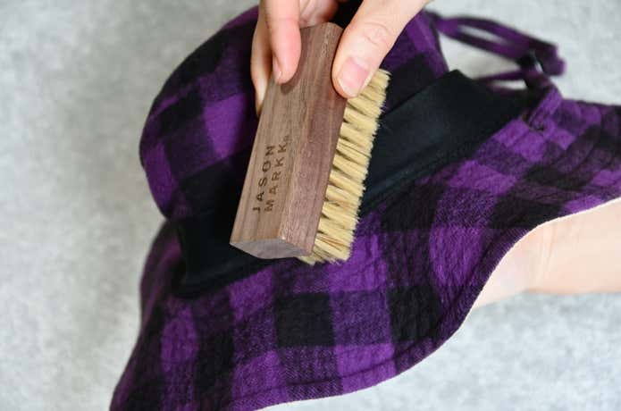 「Hat Care Kit」のブラシで帽子の汚れを取っているところ