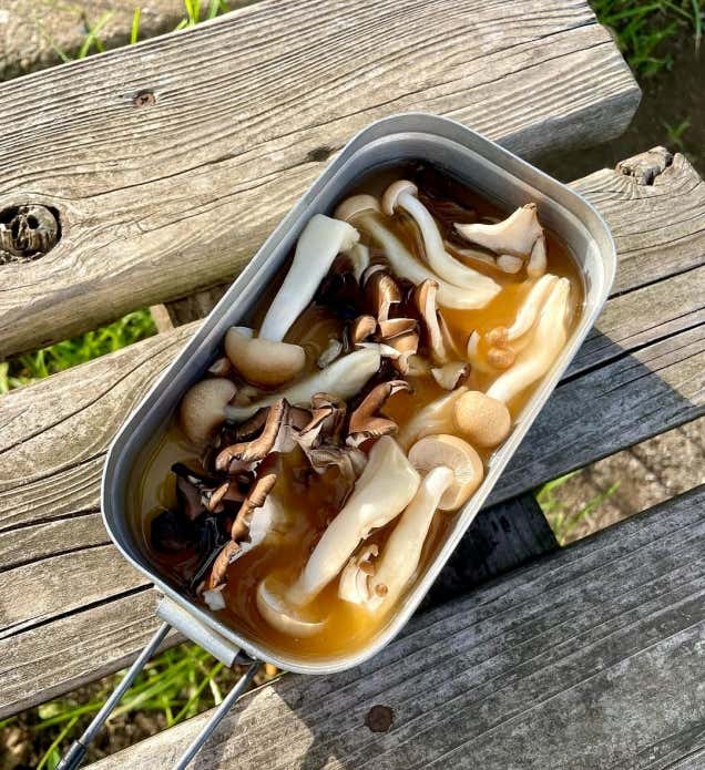 ①メスティンに洗ったお米、白だし、みりん、しょうゆ、塩を入れて、内側のリベット（丸い突起）の中心まで水を加えて調整する。

②お米の上にしめじ、まいたけをのせ、フタをして固形燃料で約20分炊く。