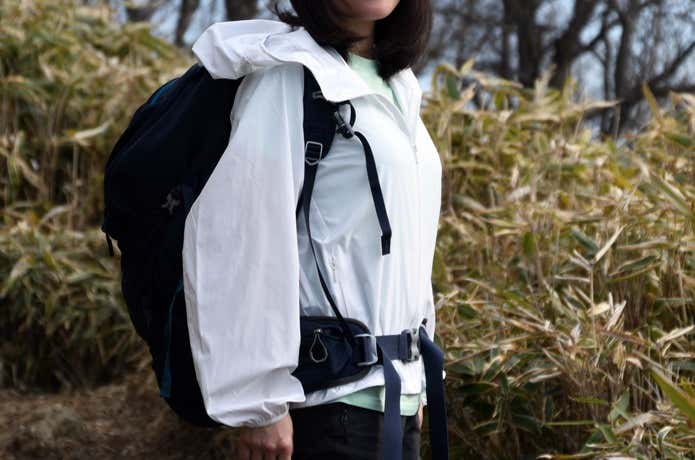 山でユニクロ「ポケッタブルUVカットパーカ/NANODESIGN」を着用し、ザックを背負った女性の上半身