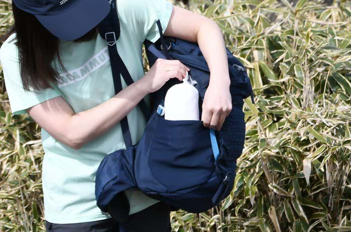 ユニクロ「ポケッタブルUVカットパーカ/NANODESIGN」をザックのサイドポケットから取り出すところ