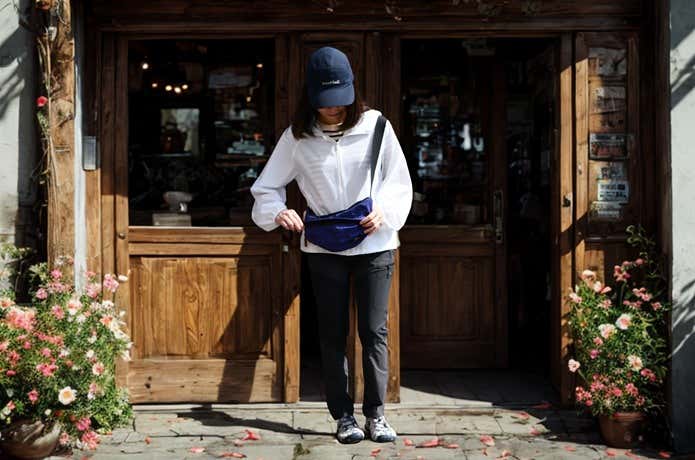 ユニクロ「ポケッタブルUVカットパーカ/NANODESIGN」を着てショップ前に立つ女性