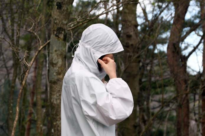 ユニクロ「ポケッタブルUVカットパーカ/NANODESIGN」のフードのアジャスターを絞って頭にフィットさせているところ