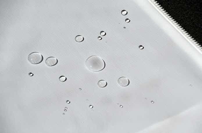 水滴が弾かれているユニクロ「ポケッタブルUVカットパーカ/NANODESIGN」の表面のアップ