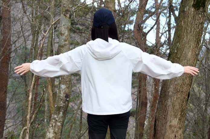 ユニクロ「ポケッタブルUVカットパーカ/NANODESIGN」を着て腕を広げた後ろ姿