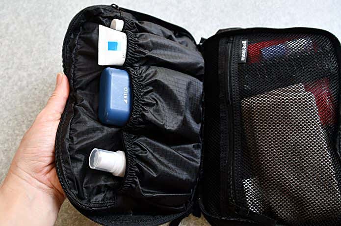 トラベルキットパックを開けて登山小物や洗面道具が整然とパッキングされているところ
