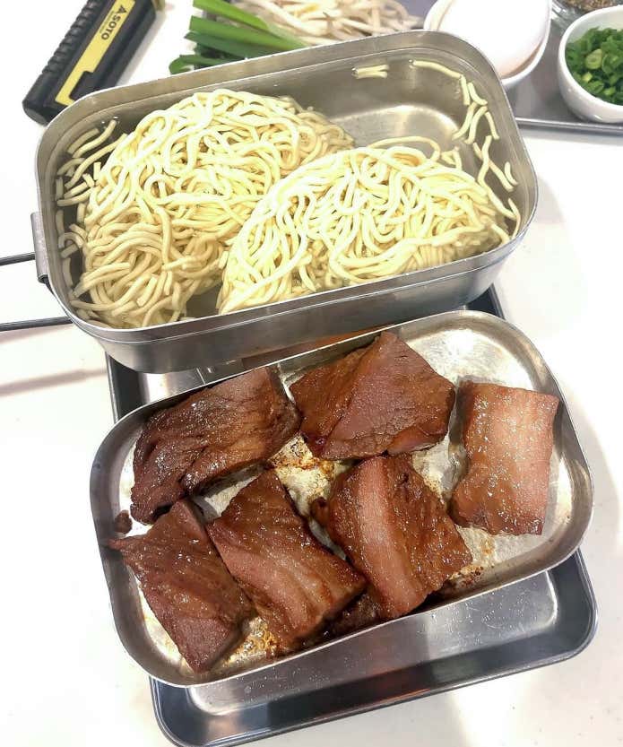 ①下準備

チャーシューをやや厚めにスライスする（炙りやすい）

②チャーシューを炙る［ここが主役］

メスティンのフタを中火にかけ、チャーシューを並べて焼く。脂が出てきて自然に焼けるので油は不要。両面にしっかりと焼き目をつける。

③ラーメンを作る

メスティン本体に水（袋の規定量）を入れて沸騰させ、麺ともやしを入れる。スープを入れてラーメンをつくる。

④仕上げ

最後にチャーシューをのせて、卵（黄身）、ねぎ、こしょうをかけたら出来上がり。