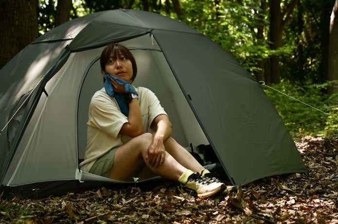 テント場で汗を拭く登山者