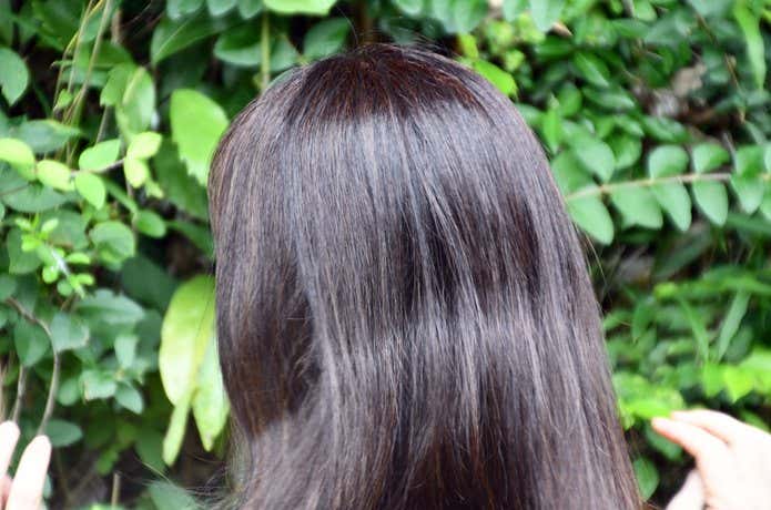 髪を一つに結んでいたため、髪の毛に結び目の跡がついている女性の後ろ姿