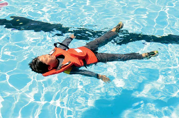 モンベル「浮くっしょん」を着用してプールで浮いている小学生