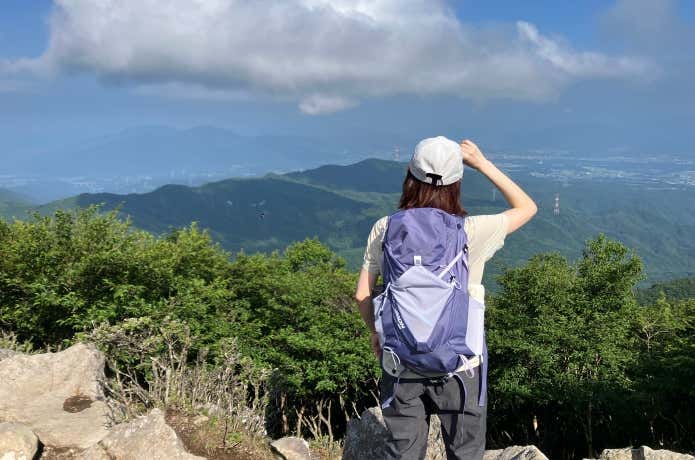 夏の低山に登る女性