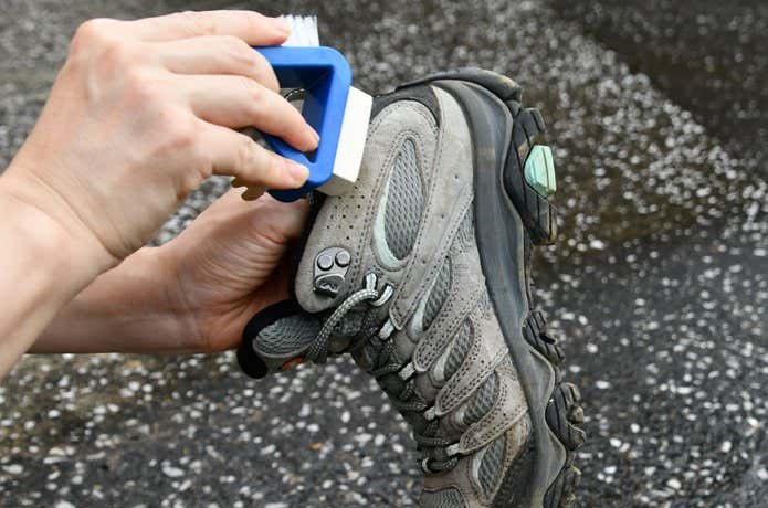 モンベル 3-Wayブーツメンテナンスブラシで登山靴のレザー部分をケアする様子